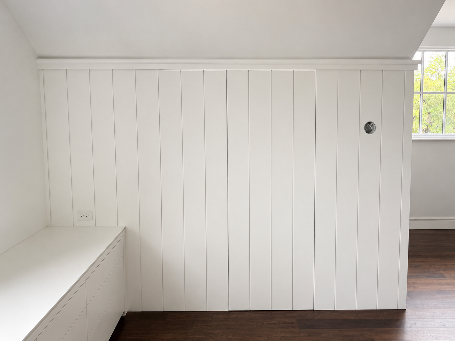 Concealed flush door within paint-grade V-groove paneling with integrated built-in drawers