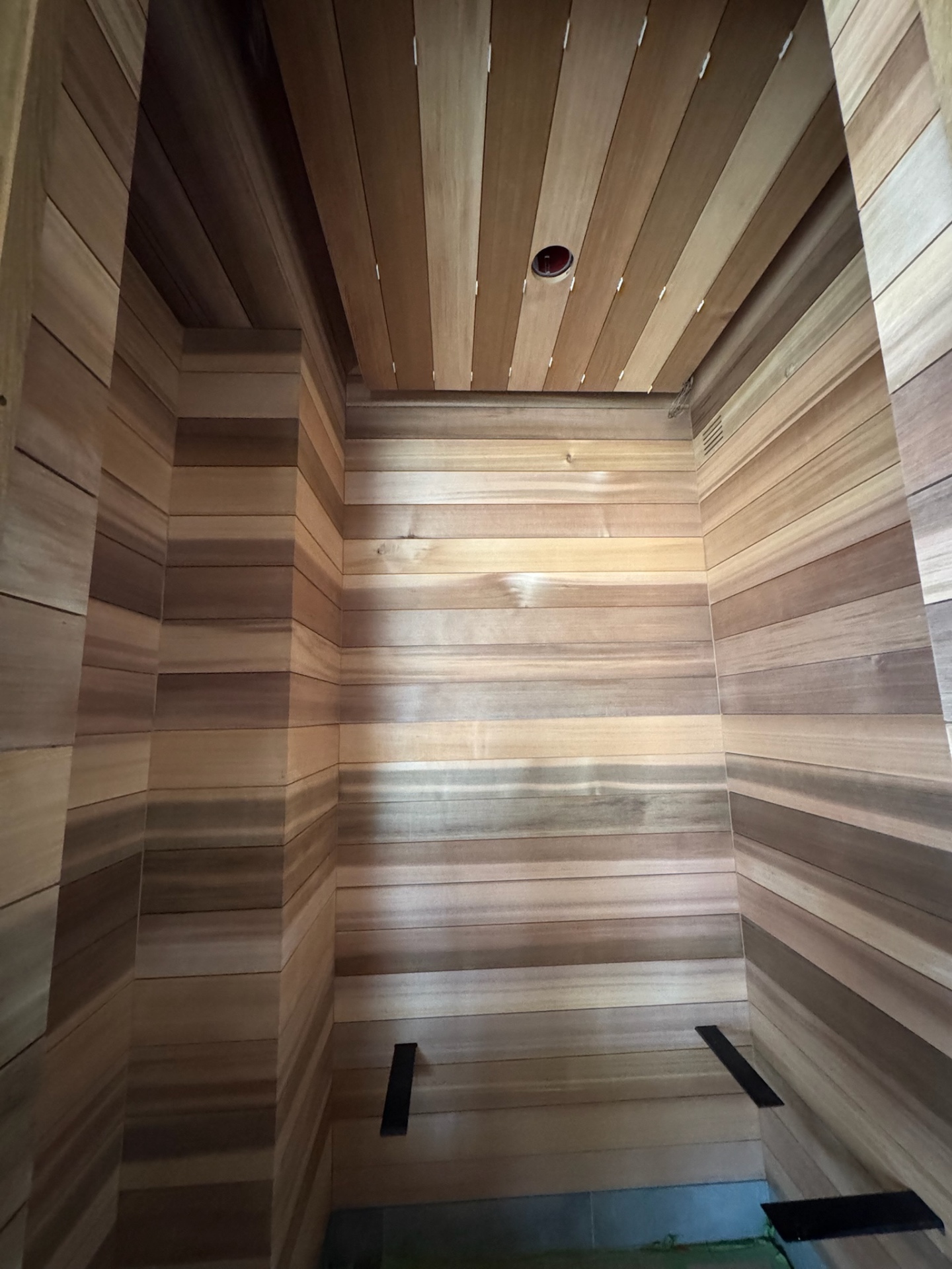 Residential sauna interior with clear cedar cladding and bench framing